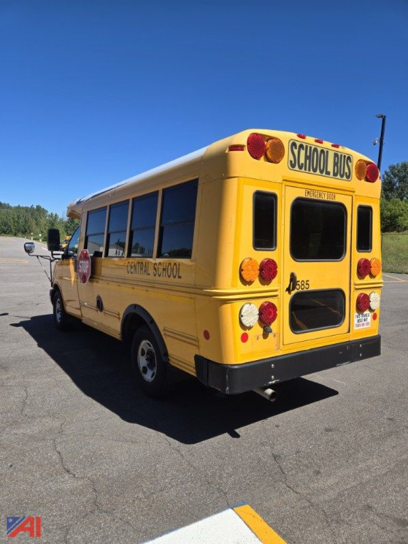 Back-right view of a yellow school bus labeled CENTRAL SCHOOL with 'SCHOOL BUS' sign on rear, 2017 Chevrolet Express G3500 Mini School Bus, black bumper, red taillights.