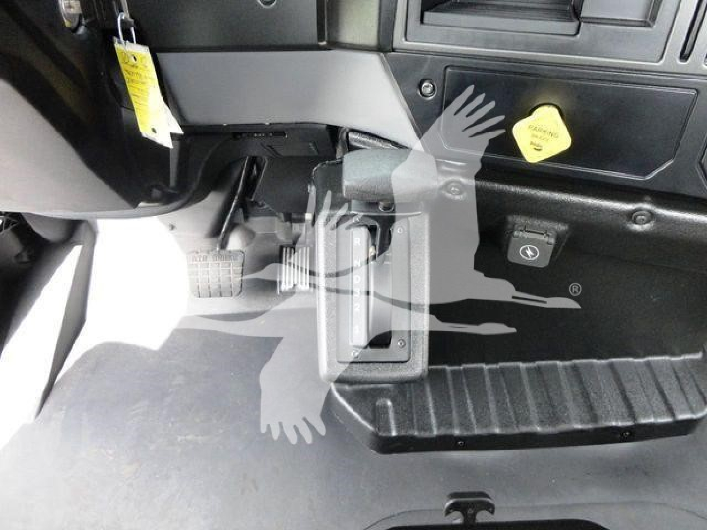 Dashboard area showing pedals and lower dash with neutral switch and step plate on a Mack MD6 rollback truck.
