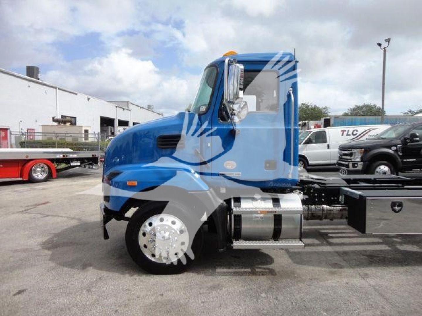 Truck cab side profile of a blue 2027 Mack MD6 rollback truck showing aerodynamic cab and chrome fuel tanks.