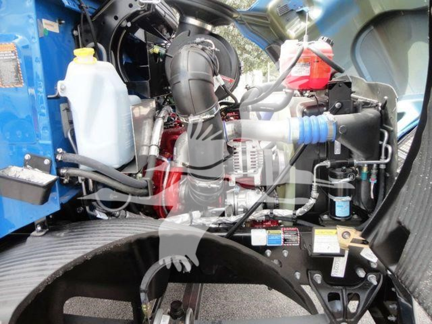 Mack MD6 engine bay and components visible with coolant reservoir, hoses, and wiring harness.