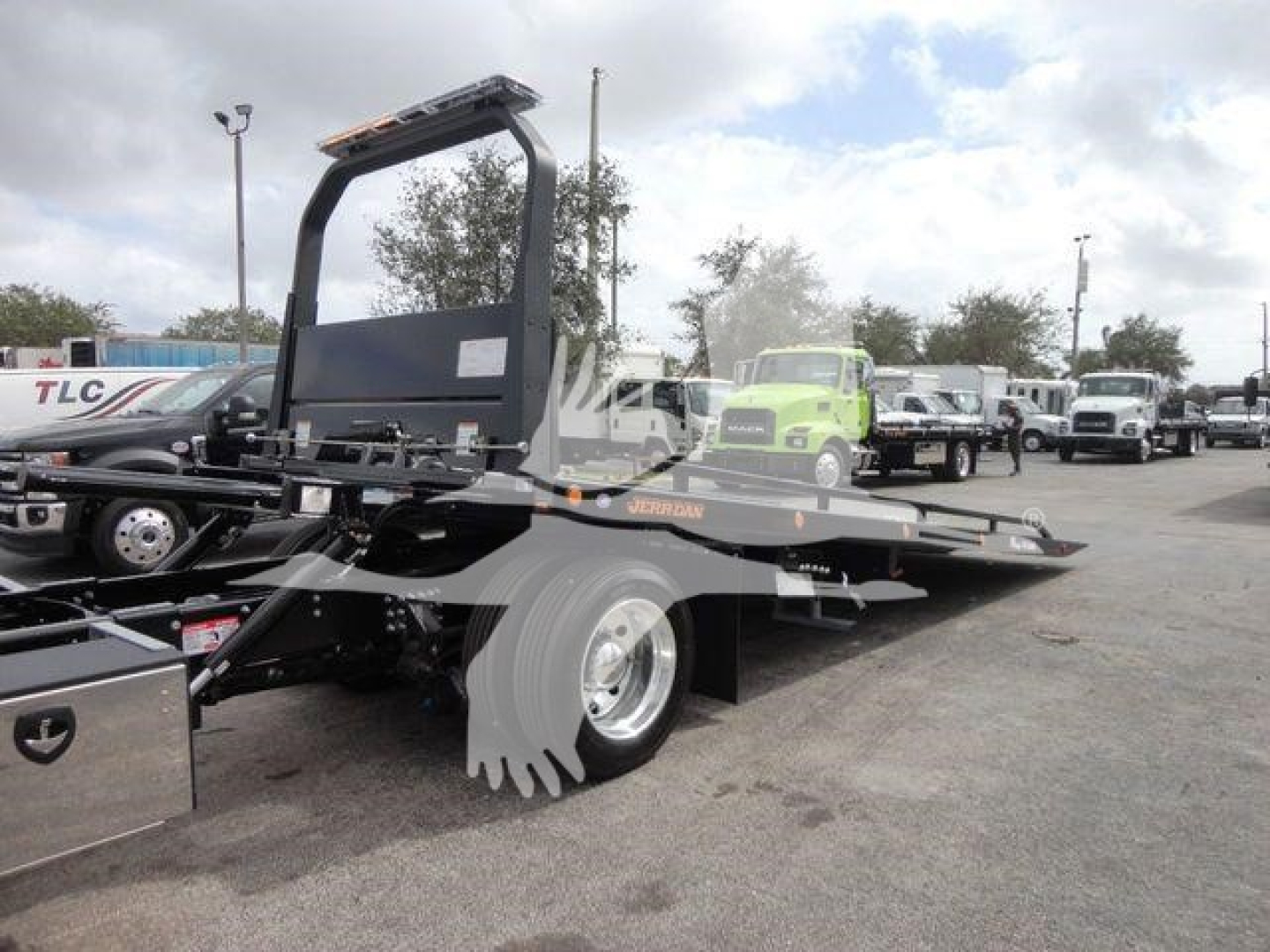 Mack MD6 rollback truck chassis showing platform and rear wheels with hydraulic system components visible.