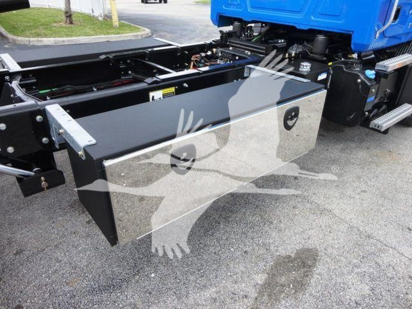 Mack MD6 chassis side view showing large silver rectangular tool/storage box mounted beneath the cab with access panel and latching handles.