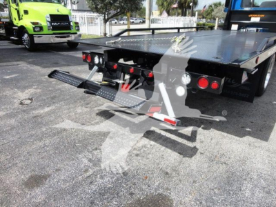 Mack MD6 rollback truck rear view showing fold-out hydraulic ramps and flatbed with rear lights.