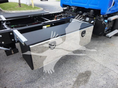 Mack MD6 chassis side view showing large silver rectangular tool/storage box mounted beneath the cab with access panel and latching handles.