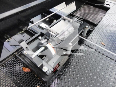Mack MD6 rollback truck mounting winch assembly with cable drum and metal deck visible.
