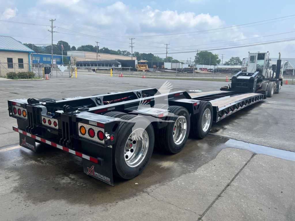XL Specialized XL110HDGS lowboy trailer with triple-axle rear, black frame, red/white reflective markings, and Gooseneck hitch visible.