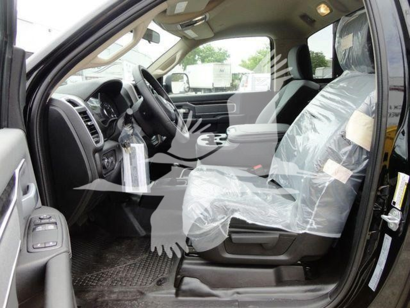 Interior of a 2024 Ram 4500 SLT truck showing front seats, steering wheel, and protective plastic covers on the seats.