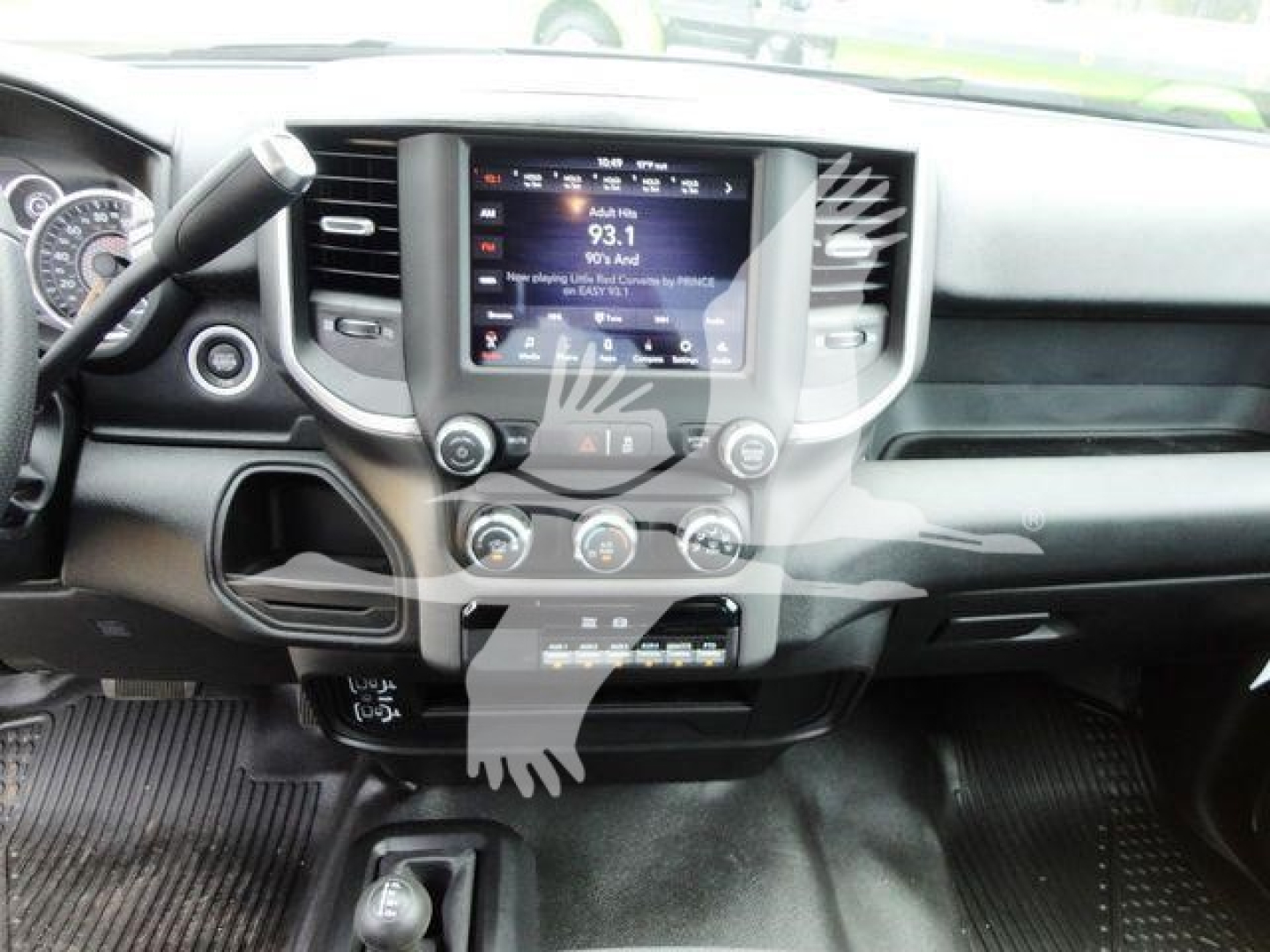 Ram 4500 dashboard and center console with touchscreen display showing radio station 93.1 and climate controls below. Steering wheel left, gear selector area, glove compartment and dashboard trim.