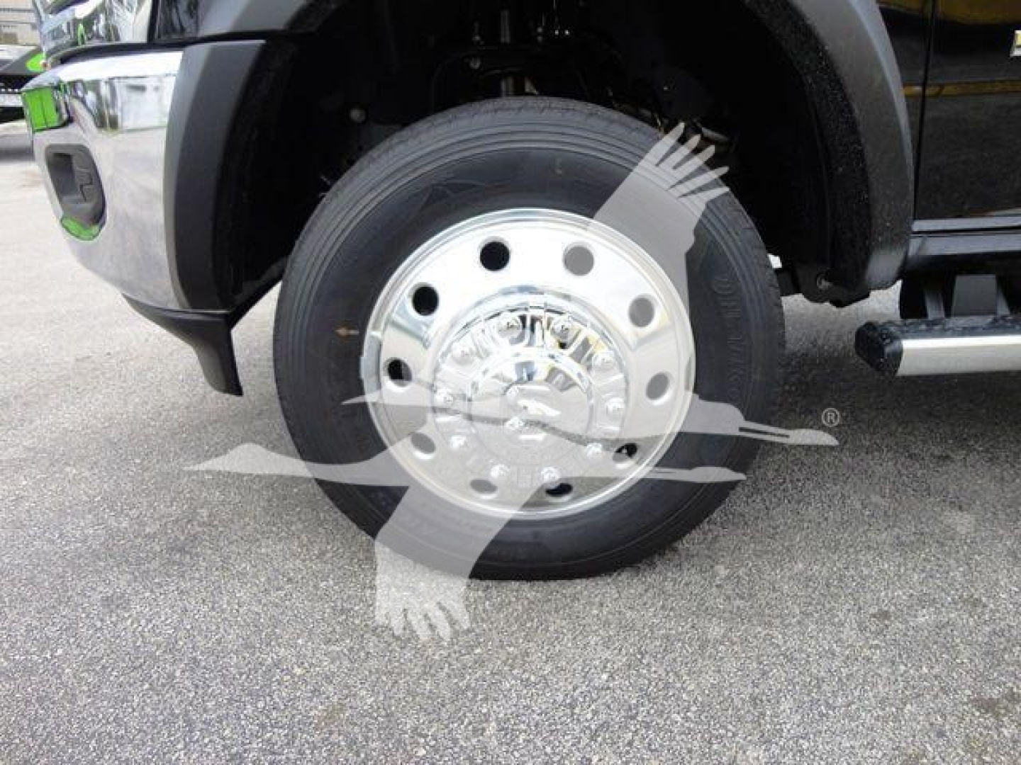 Ram 4500 truck front wheel showing polished steel hubcap and black tire, partial fender and side step visible.