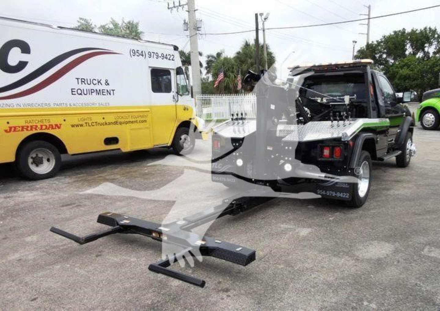 Ram 4500 SLT pickup with a tow hitch and a damaged front; a tow truck in the background; a yellow service van with 'TRUCK & EQUIPMENT' markings.