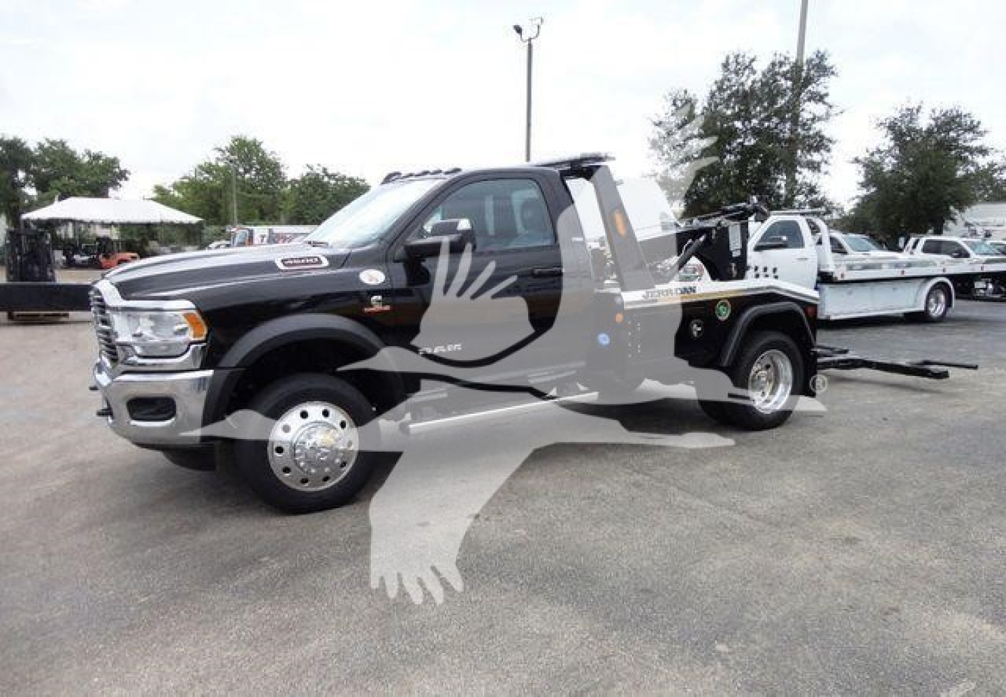 Ram 4500 SLT tow truck with winch setup showing front quarter and extended bed, black with chrome wheels.