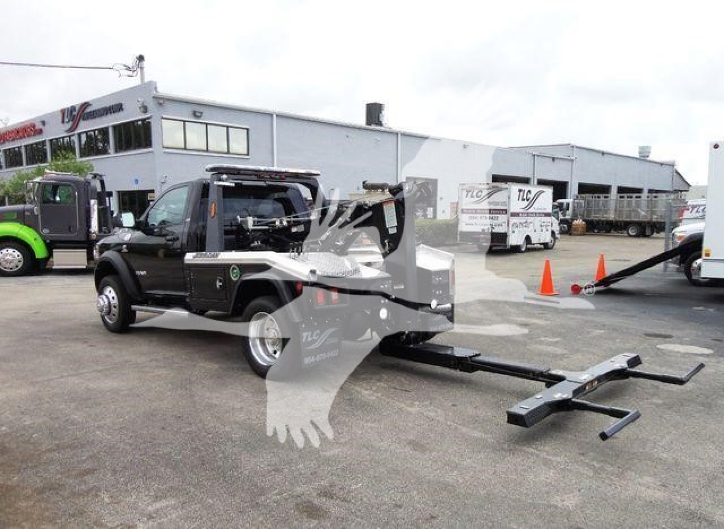 Ram 4500 SLT pickup truck with a large tow winch attachment in a dealership lot, showing front and side view.