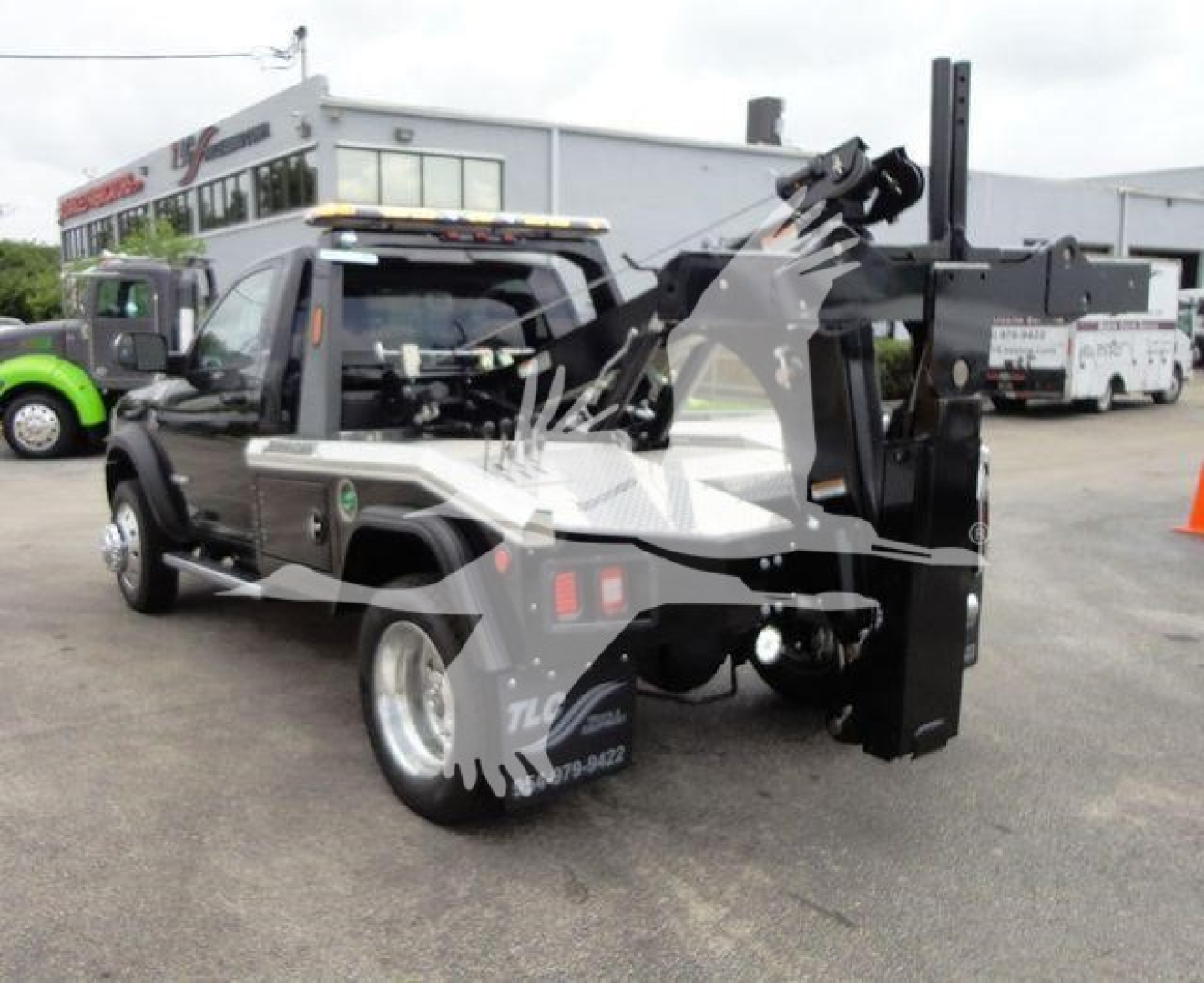 Ram 4500 tow truck with mounted hydraulic winch arm in rear underlift setup, side view showing black equipment and chrome accents.