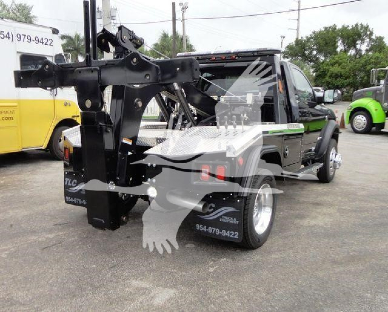 Ram 4500 tow truck with front winch and hydraulic arm, side view showing crane, black and gray color, stock number J68872