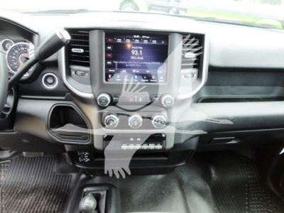 Ram 4500 dashboard and center console with touchscreen display showing radio station 93.1 and climate controls below. Steering wheel left, gear selector area, glove compartment and dashboard trim.