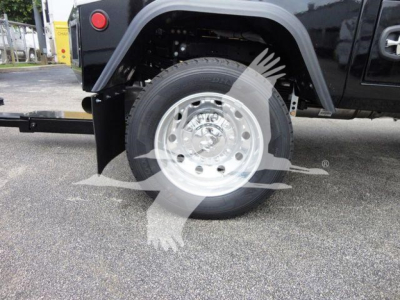 Truck wheel and fender viewed from side showing steel wheel, tire, and rear portion of Ram 4500 SLT; winch category label visible.