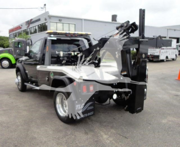 Ram 4500 tow truck with mounted hydraulic winch arm in rear underlift setup, side view showing black equipment and chrome accents.