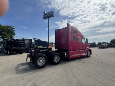 Volvo VNL64T860 sleeper tractor side view showing pink cab and rear dual wheels.