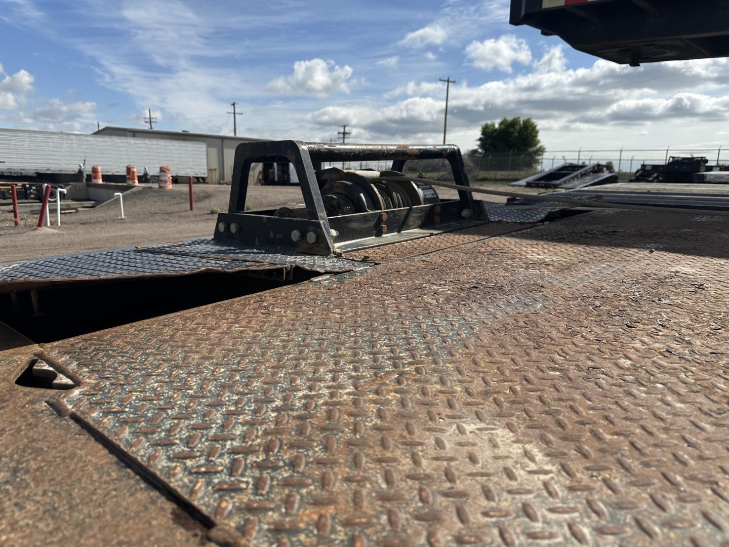 40-ton Trail King hydraulic tail trailer deck with diamond plate surface and winch/tensioning components visible