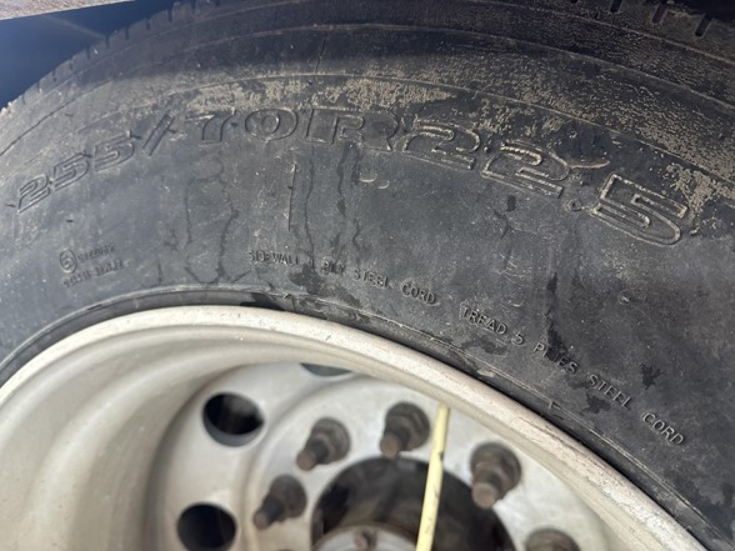 Trailer tire and wheel close-up with visible tire markings 225.5/75R17.5 and wheel studs
