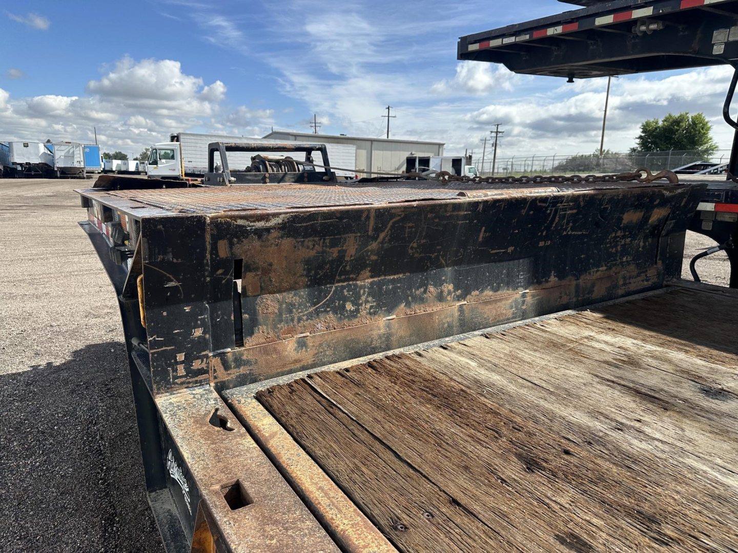 Trailer King 40 ton hydraulic tail on flatbed trailer showing worn steel deck and rust patches with clear view of tail area and support frame.