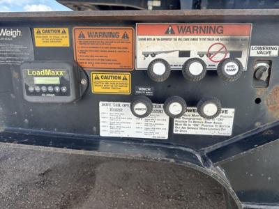 Trailer control panel with LoadMaxx display, multiple warning labels, and gauge icons showing hydraulic tail setup on a 2017 Trail King 40 Ton hydraulic tail trailer.