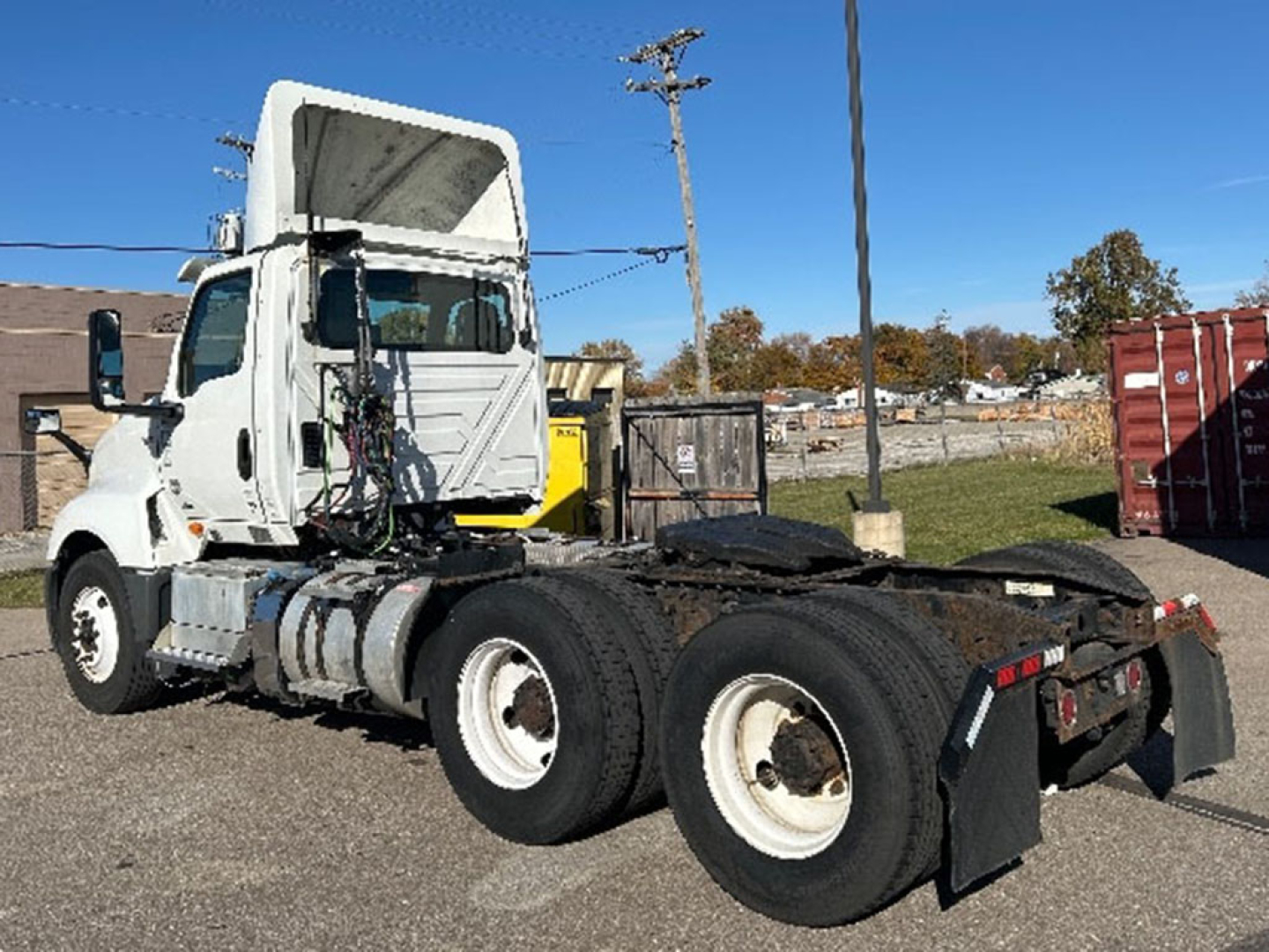 Truck chassis of a white 2019 International LT625 in-service with exposed engine area, cab, and dual rear axles; side view showing fuel tanks and steps.