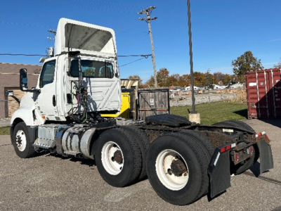Truck chassis of a white 2019 International LT625 in-service with exposed engine area, cab, and dual rear axles; side view showing fuel tanks and steps.