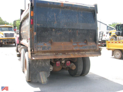 Dump truck rear view showing International 7600 WorkStar equipment with large blue dump box and dual rear wheels.