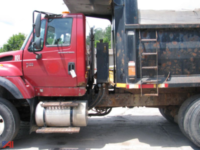 Truck cab and dump bed side view showing International 7600 WorkStar logo and fuel tank under the door