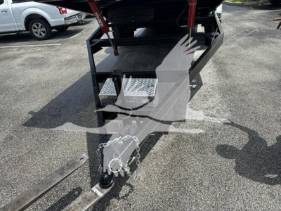 Trailer hitch and front platform with safety chains and a diamond-plate step, 2-way hitch ball and coupler visible