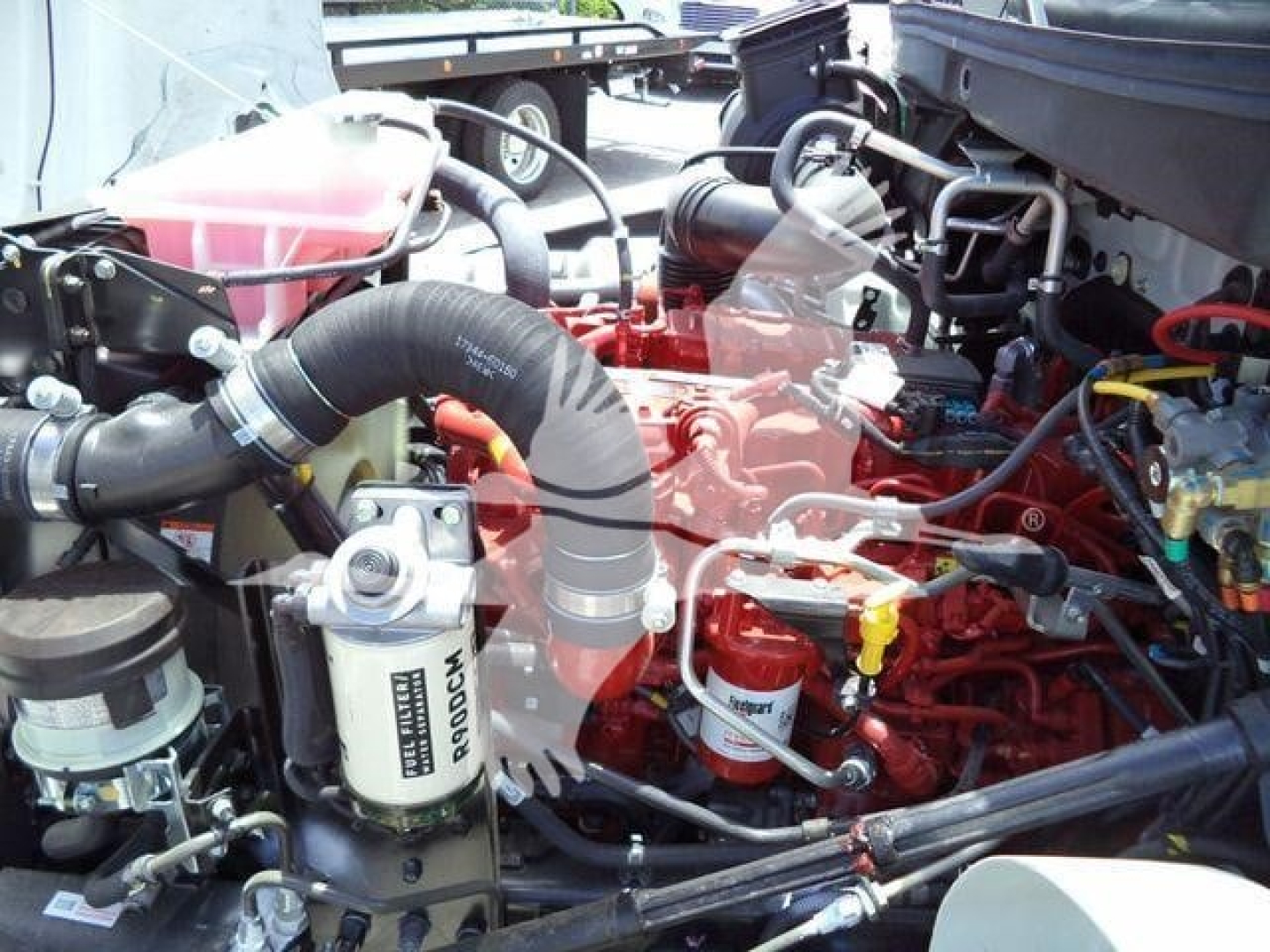 Hino L6 engine bay with red engine block, hoses, and filter visible; various components and tubing in view