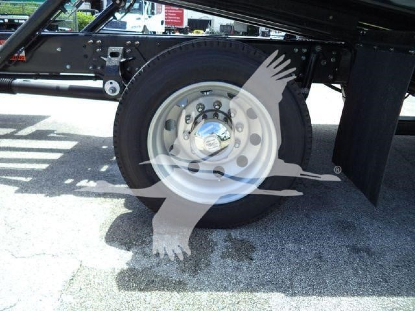 Truck rear wheel and chassis of a new Hino L6 rollback truck with spare wheel hub and frame visible.