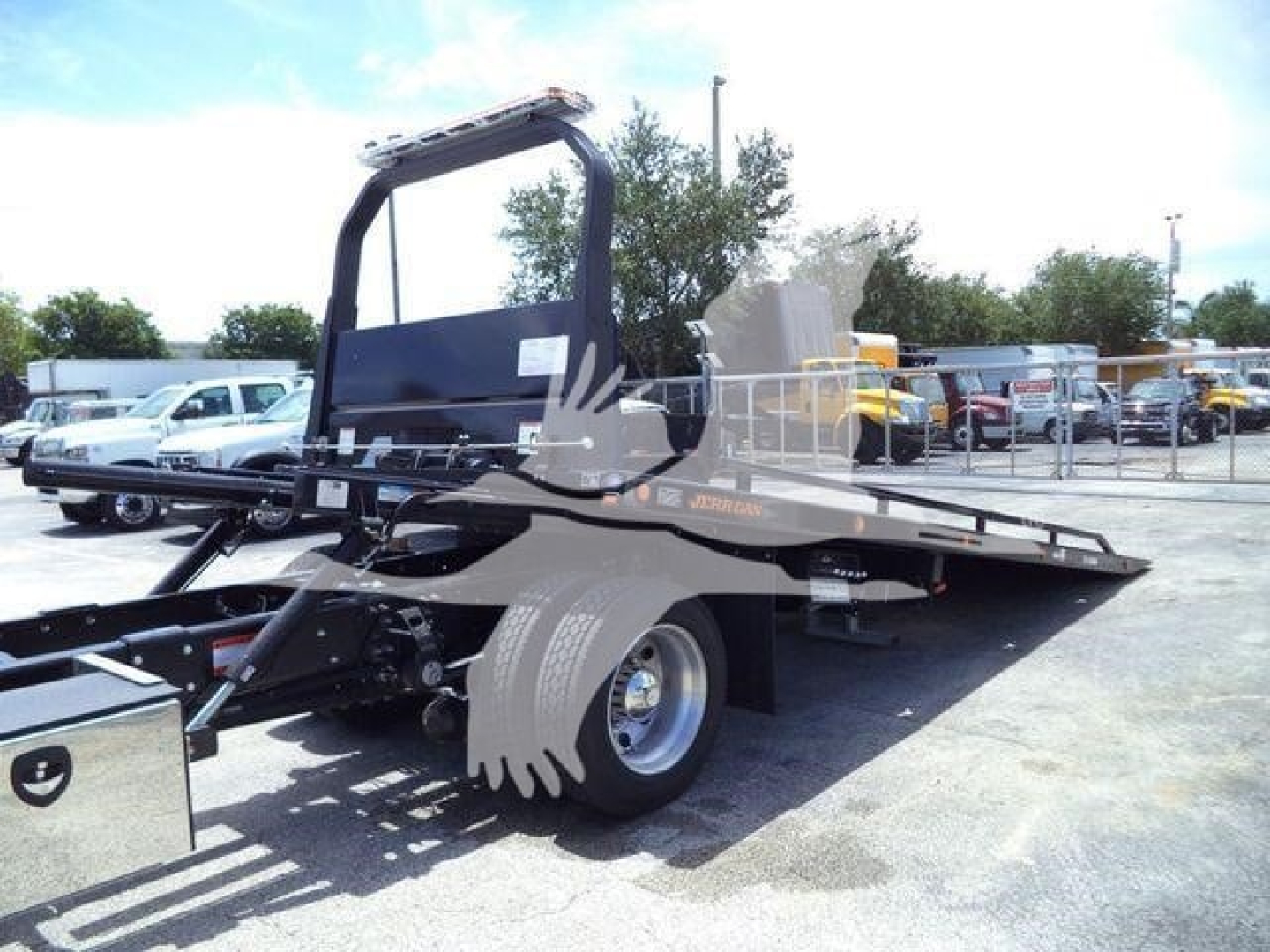 Hino L6 rollback truck chassis and flatbed with hydraulic ramp, side view showing wheel and bed structure.
