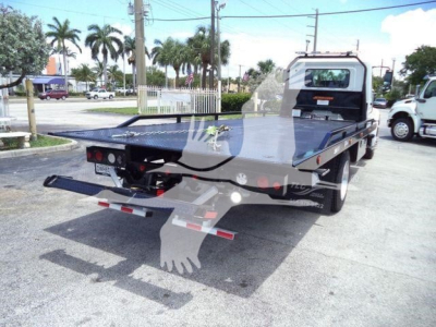 Flatbed tow truck rear view showing rollback platform and rear lights.