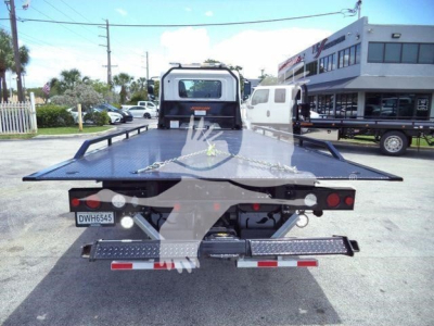 Flatbed tow truck bed with metal diamond plate rear, rear lights, and license plate DWH6545 visible.