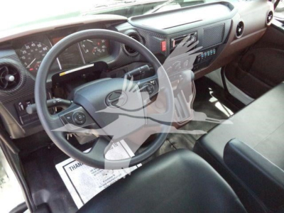 Truck cab interior showing steering wheel and dashboard; gear shift on center console; driver's seat; some controls and pedals visible.