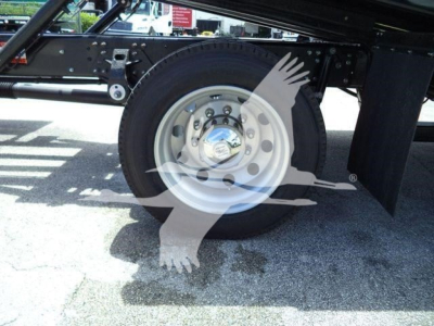 Truck rear wheel and chassis of a new Hino L6 rollback truck with spare wheel hub and frame visible.