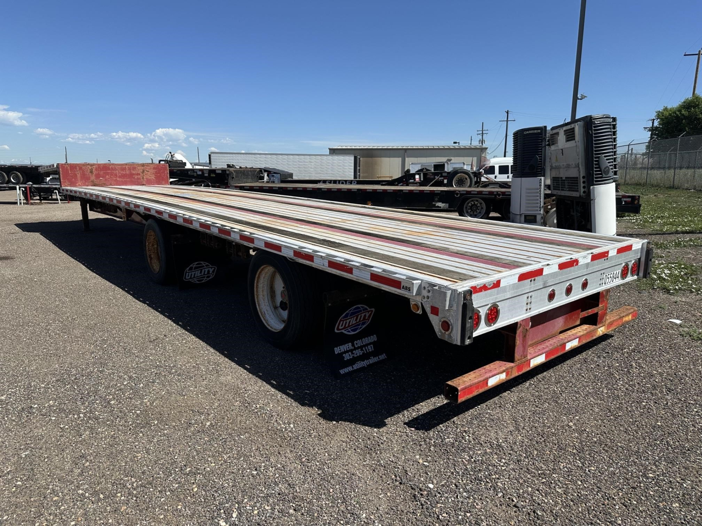 Flatbed trailer showing Fontaine spread air combo drop deck with dual rear axles and aluminum deck.