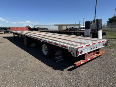 Flatbed trailer in an outdoor lot showing a Fontaine spread air combo drop deck with long silver deck and red accents.