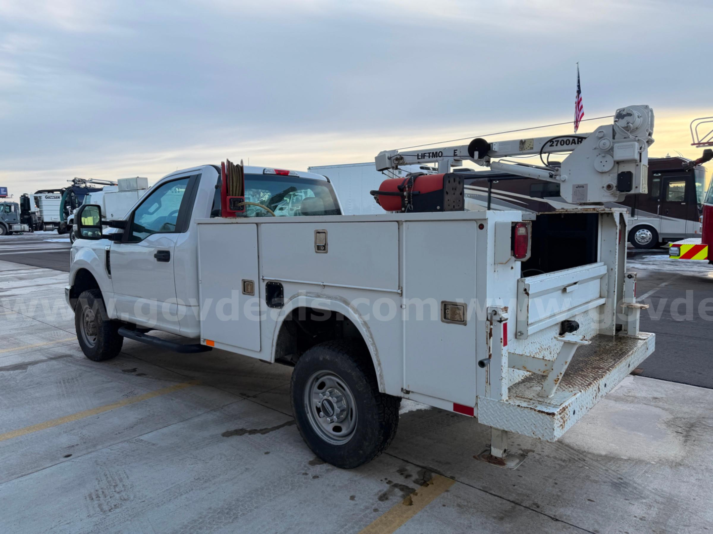 2019 Ford F250 Super Duty XL utility service truck with service body and bucket lift, rear platform visible, white exterior.
