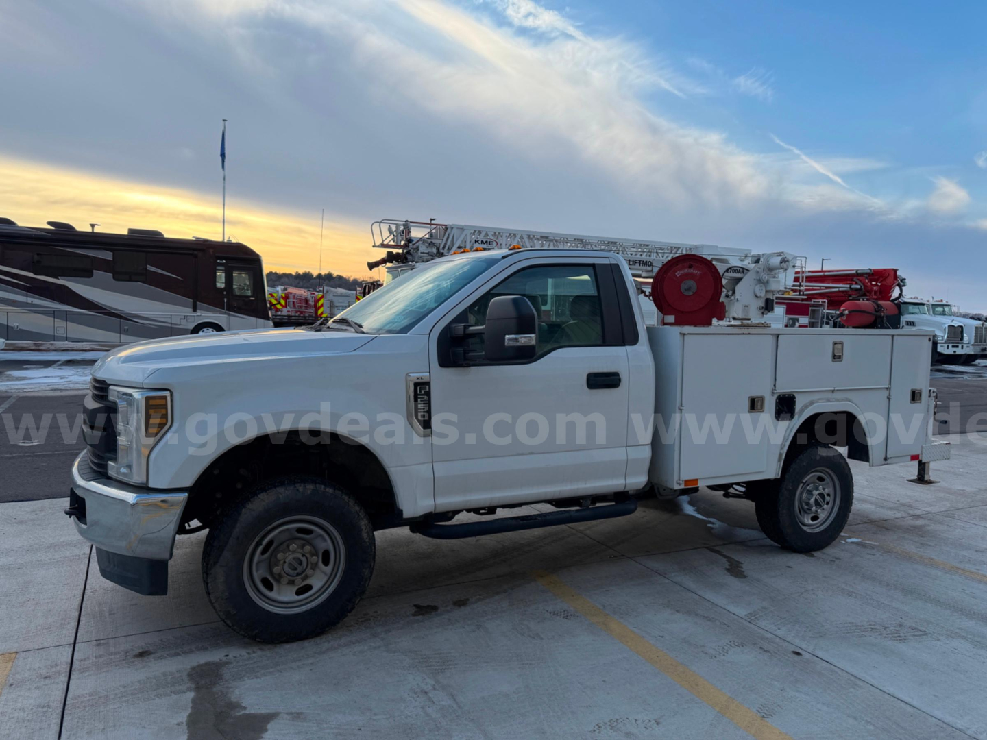 2019 Ford F250 Super Duty XL service truck in a parking lot; features utility body with hose reel and compartments.