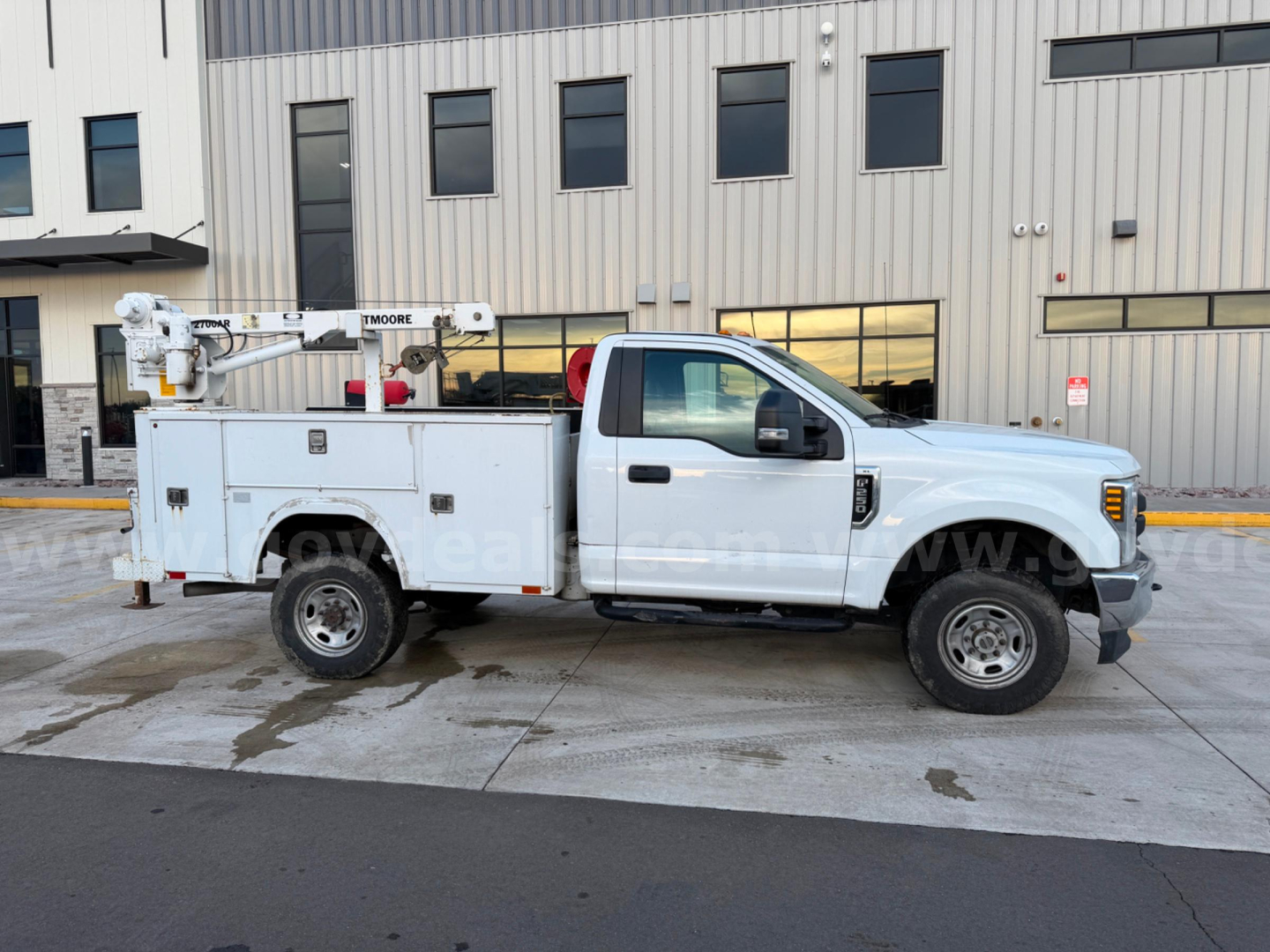Ford F-250 Super Duty XL utility service truck in side view with bucket lift, white cab and utility bed, stock number 24329-545 visible.