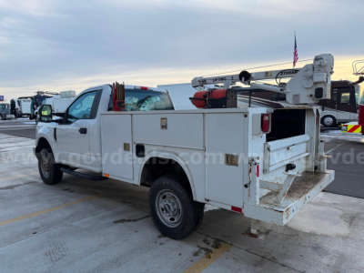 2019 Ford F250 Super Duty XL utility service truck with service body and bucket lift, rear platform visible, white exterior.