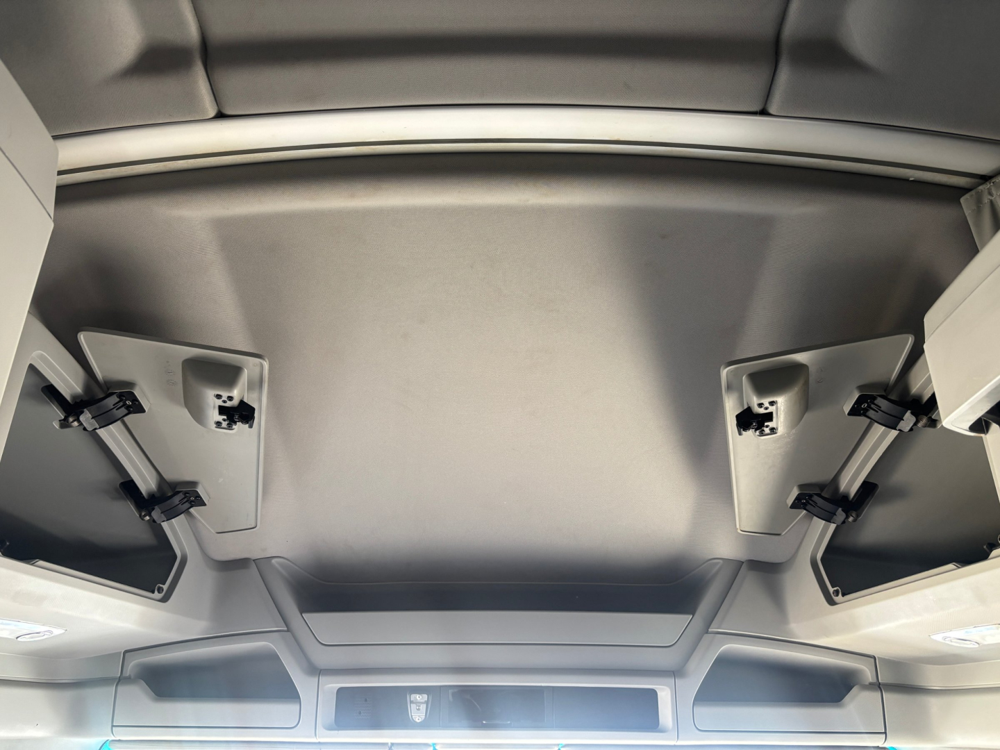 Kenworth T680 cabin ceiling interior with overhead panels and sun visors, showing molded headliner and storage compartments.