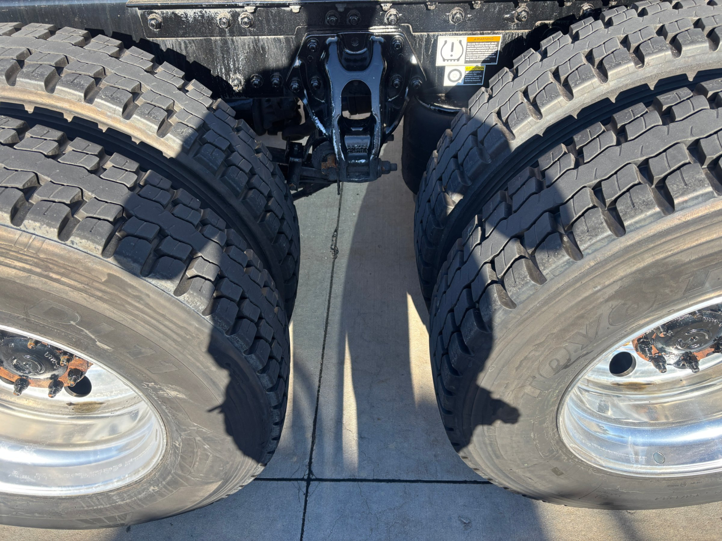 Kenworth T680 truck tandem rear wheels showing dual tires and suspension components.