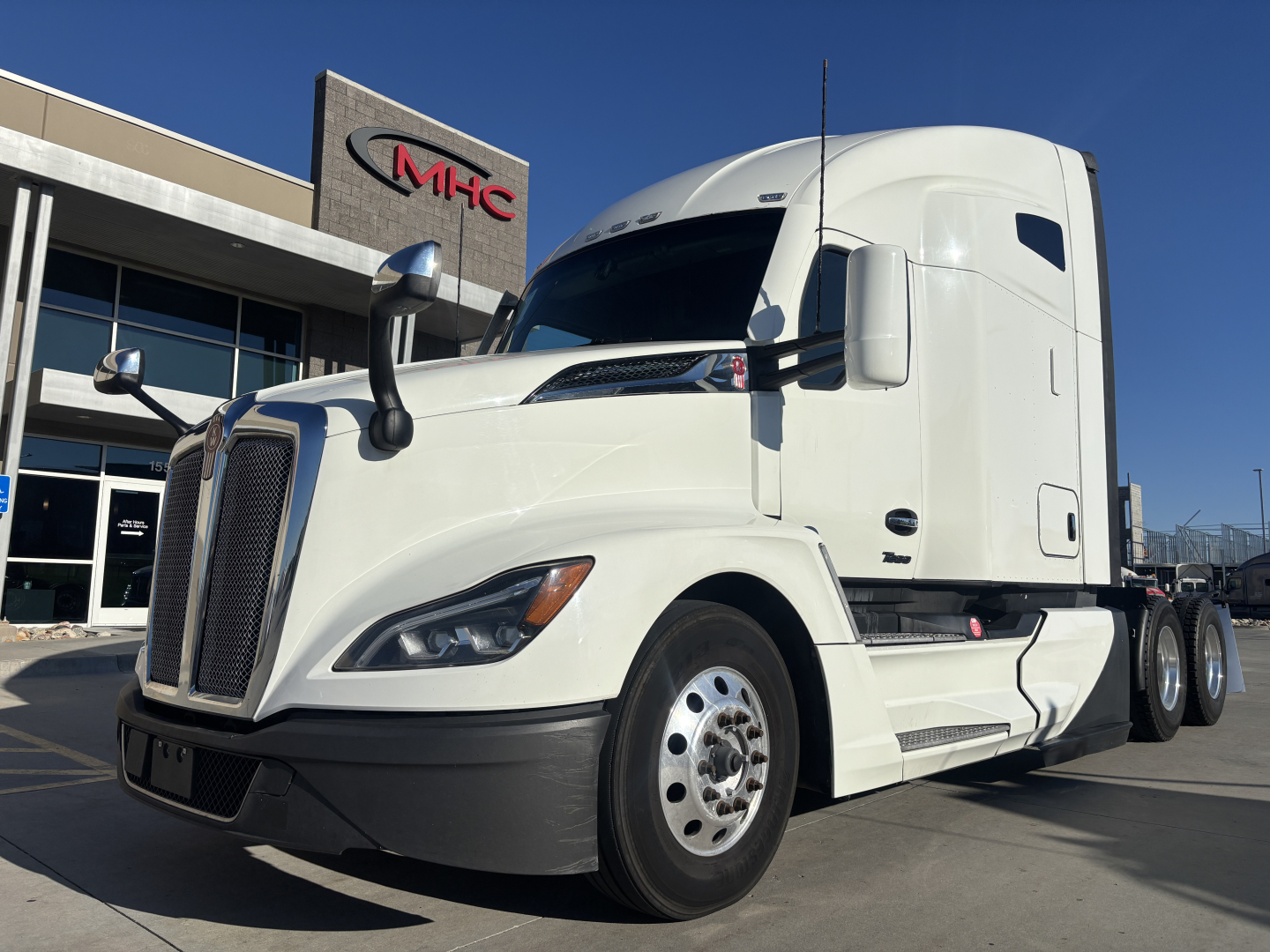 Kenworth T680 main view showing front grille and side cab with sleeper compartment and white paint.