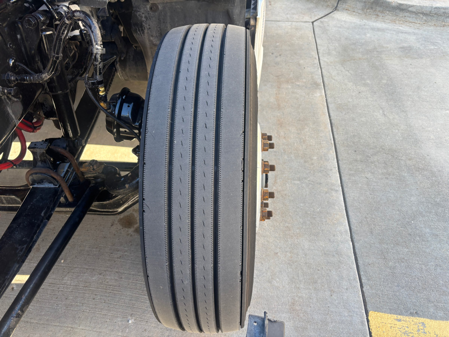 Kenworth T680 wheel and front suspension view showing dual-tire axle and drivetrain components.