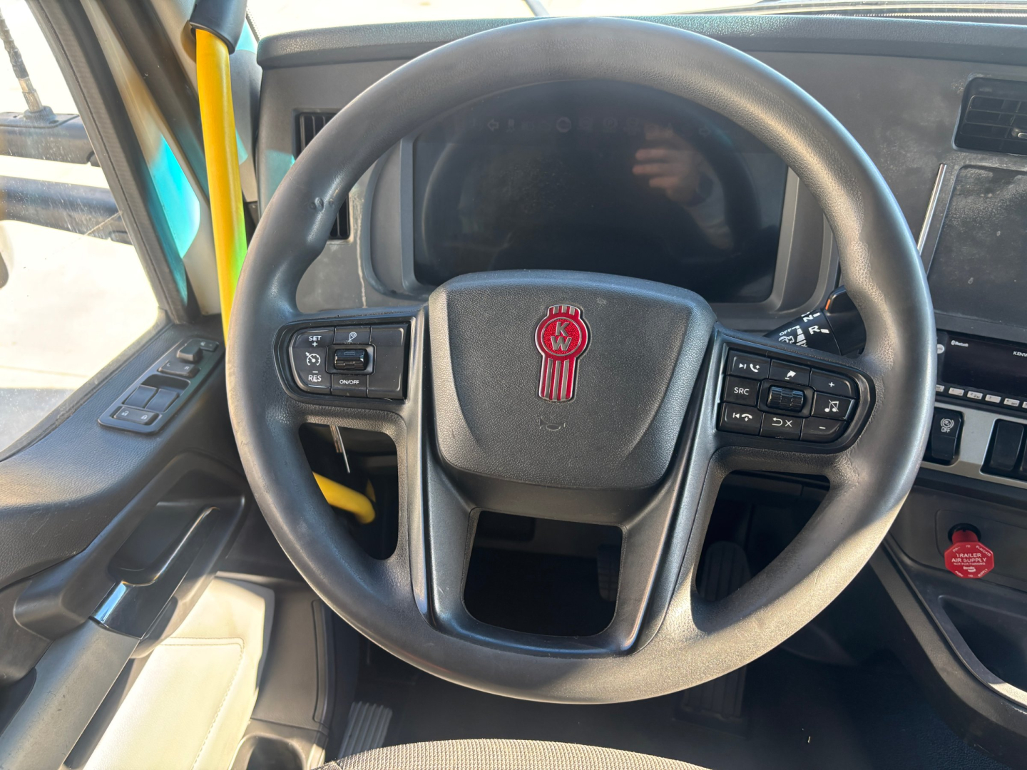 Kenworth T680 truck interior steering wheel and dash from driver seat view with Kenworth emblem visible