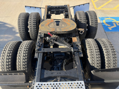 Kenworth T680 chassis view showing fifth wheel and dual rear axles with dual tandem configuration, visible fuel tanks, and suspension components.